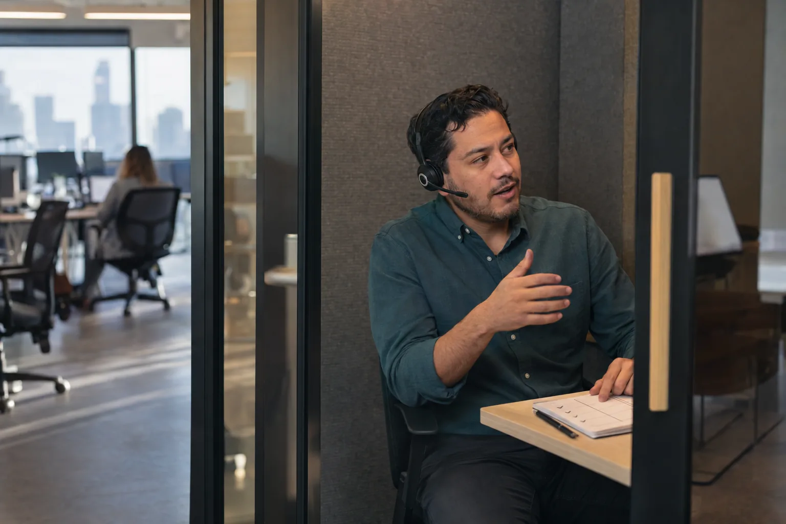 A rep does a short practice call with a headset in an office phone booth