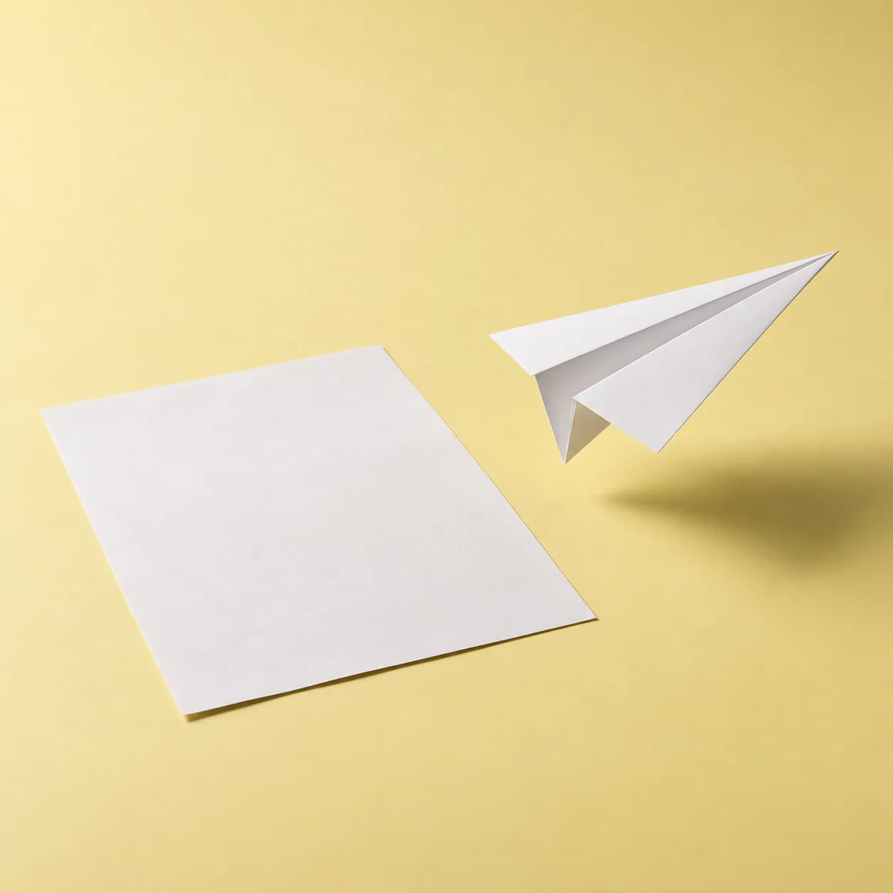 A flat sheet of paper beside a paper plane lifting off