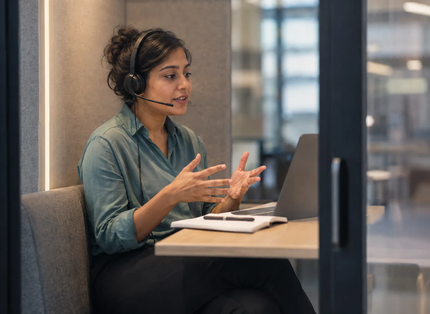 A founder rehearses a sales call on a headset in a phone booth
